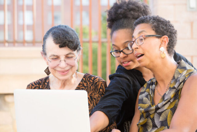 Three woman looking at a laptop