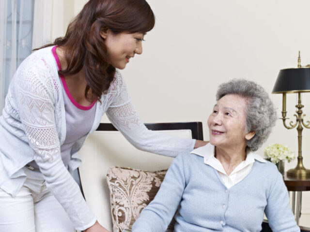Young and old woman smiling at eachother