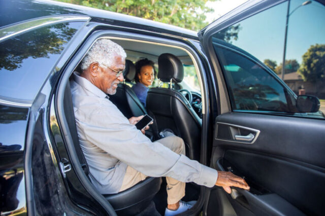 Old man getting out of a car